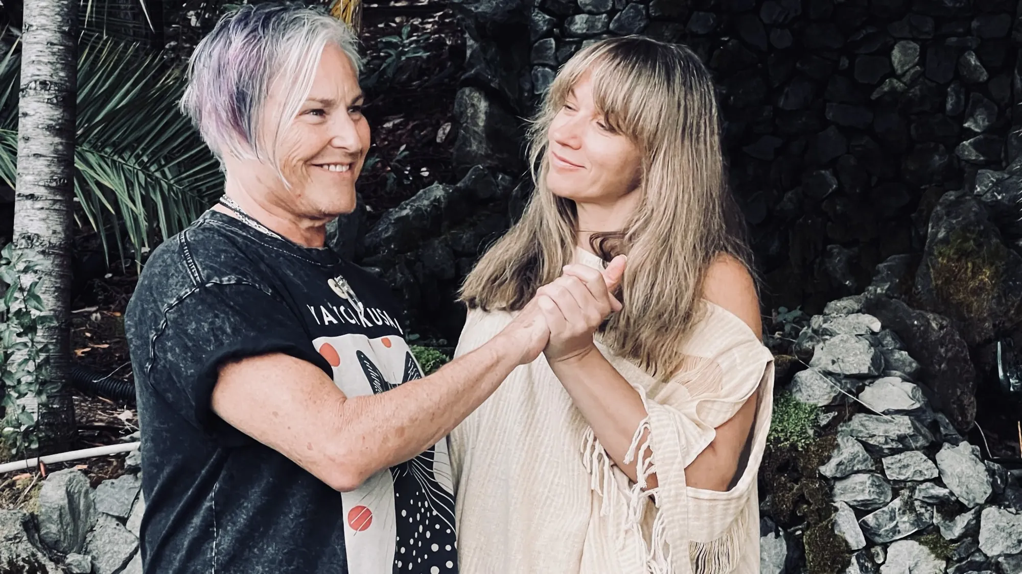 Lana Elco holding hands with an apprentice outdoors